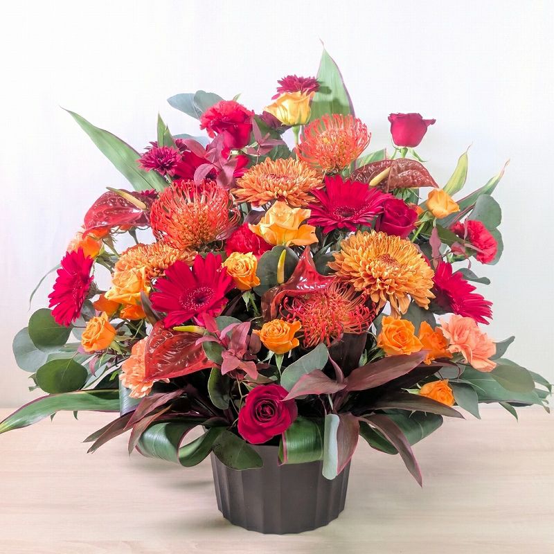オレンジ色と赤色の花束、おしゃれなアレンジメント。会社のお祝い・記念日に喜ばれるお花のギフト
