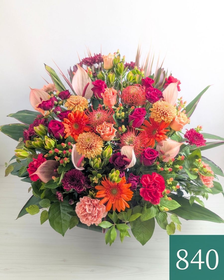 オレンジ色と赤色の花束、おしゃれなアレンジメント。会社のお祝い・記念日に喜ばれるお花のギフト