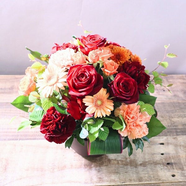 オレンジ色と赤色の花束、おしゃれなアレンジメント。会社のお祝い・記念日に喜ばれるお花のギフト