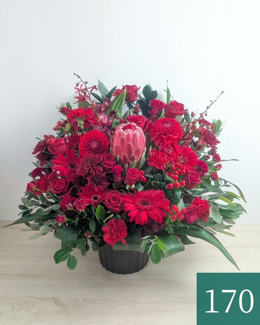 赤色の花、アレンジメント。ビジネスのお祝いに贈るフラワーギフト。