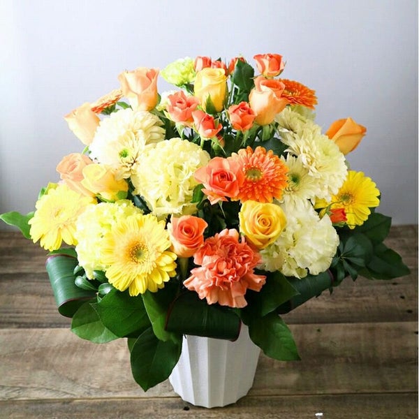 お花のプレゼント、贈り物。黄色とオレンジ色の花束・アレンジメントを贈る。フラワーギフト