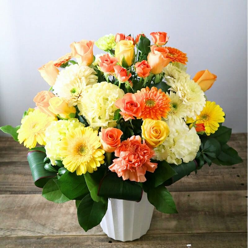 お花のプレゼント、贈り物。黄色とオレンジ色の花束・アレンジメントを贈る。フラワーギフト