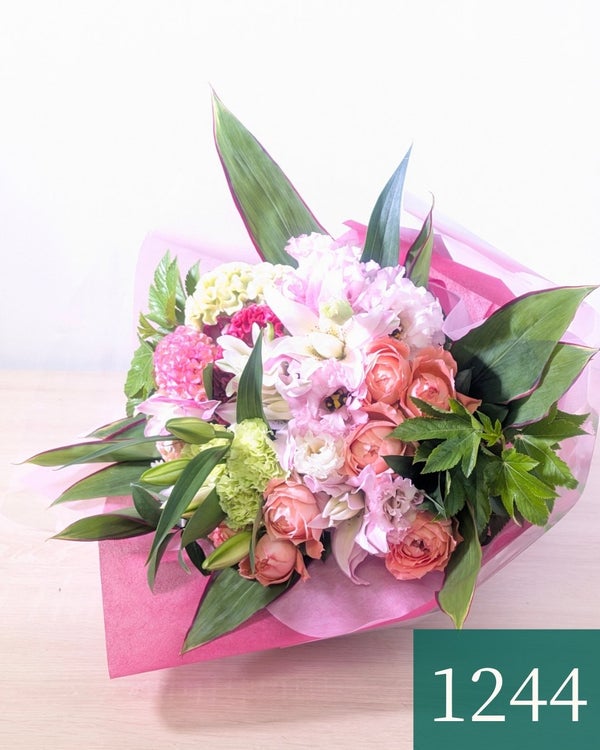 お花のプレゼント、贈り物。オレンジ色とピンク色の花束・アレンジメントを贈る。フラワーギフト