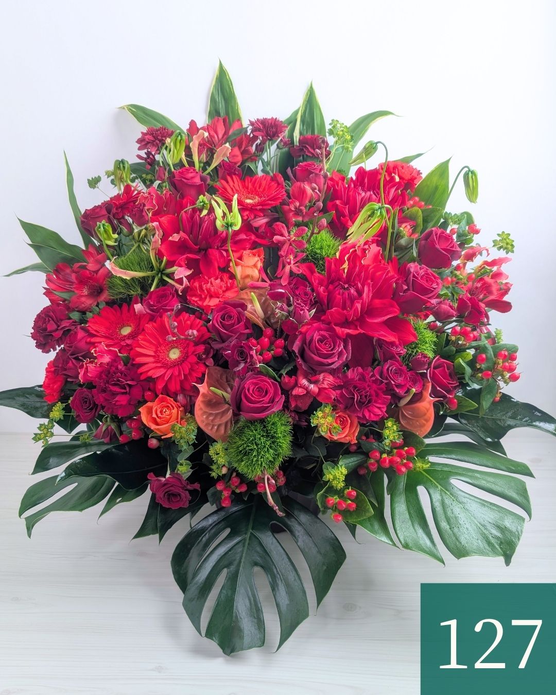 赤色の花、アレンジメント。ビジネスのお祝いに贈るフラワーギフト。